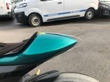 a motorcycle parked in a parking lot with a van in the background