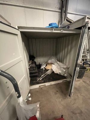 un chien qui se trouve à l'intérieur d'un conteneur dans le garage