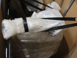 un chat enveloppé dans du plastique et emmitouflé dans une chaise
