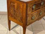 a small wooden chest of drawers on a tiled floor