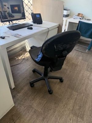 a desk with a computer and a chair in the room
