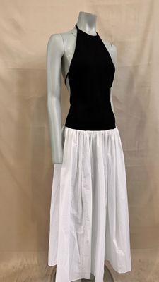 the mannequin is wearing a black top and white skirt