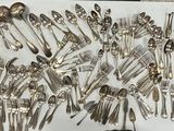 de nombreuses cuillères en argent et des cuillères à soupe disposées sur un plateau