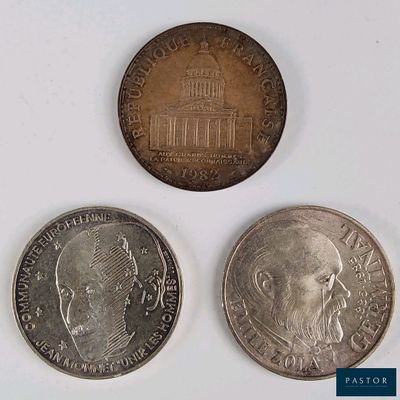 three different coins are shown on a white surface with a blue background