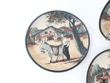 three plates with pictures of people on them on the wall