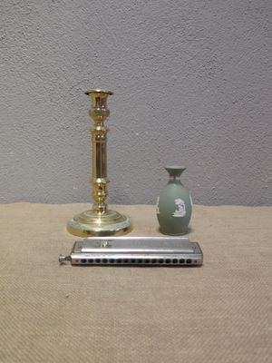 une bougie dorée et un vase vert posés sur une table