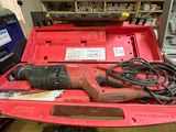 une boîte à outils rouge contenant des outils, posée sur un établi