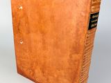 an old book with a brown cover sitting on top of a table