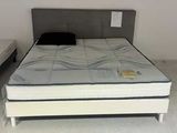 un lit sur lequel est posé un matelas dans une pièce