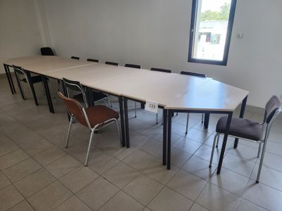 des tables et des chaises dans une pièce dotée d'une grande fenêtre et d'un sol carrelé