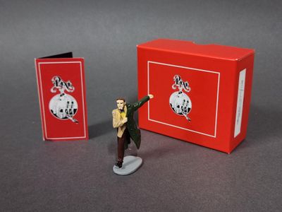 figurine représentant un homme en costume-cravate tenant une boîte rouge