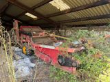 a large red machine that is sitting in the grass