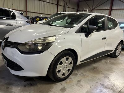 La voiture blanche est garée dans un garage, avec d'autres voitures en arrière-plan.