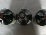 three bottles of wine are lined up on a white surface