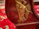 a wooden clock with an angel on it on a red carpet