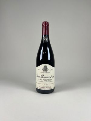 une bouteille de vin rouge posée sur une table blanche