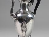 une théière ancienne en argent, dotée d'une poignée noire et d'une poignée noire