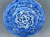 a blue and white bowl with a flower design on it