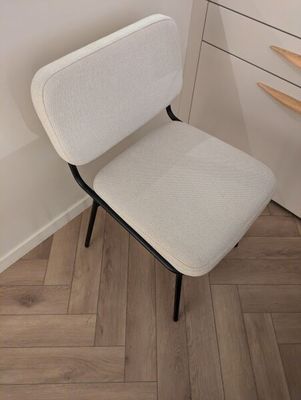 une chaise blanche posée dans un coin d'une pièce