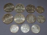 six different types of silver coins on a blue surface