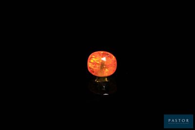 gros plan d'un diamant orange sur une surface noire