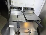 two deep fryers sitting on a counter in a kitchen