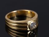 une image représentant une bague en or sertie de deux diamants sur un fond noir