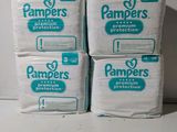 quatre paquets de couches Pampers empilés les uns sur les autres