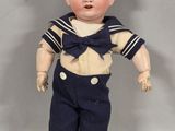 a small doll that is wearing a sailor outfit