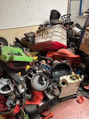 a pile of assorted motor parts in a garage