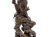 statue of a man sitting on a rock with a cup in his hand