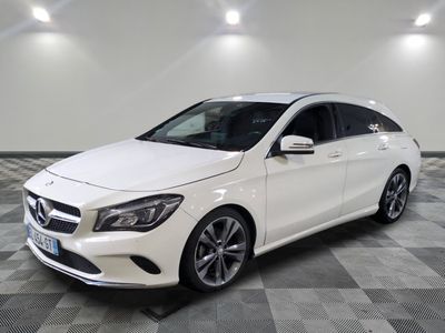 Une Mercedes CLA blanche est garée dans une grande pièce