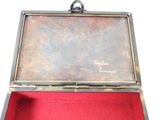 a small metal box with a red cloth inside