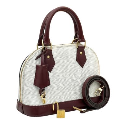 a white and maroon handbag with a belt on a white background
