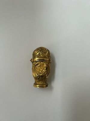 a close up of a gold plated object on a white surface
