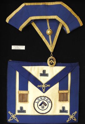 une image représentant un tablier maçonnique bleu et or orné d'une croix
