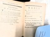 un chat noir assis sur un livre ouvert