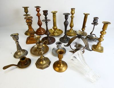 many different types of brass candlesticks on the table