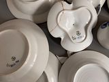 a lot of white plates and bowls sitting on a table