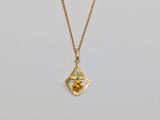a gold plated necklace with a small yellow flower on a chain