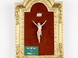 an image of a crucifix is displayed in a gold frame on a red wall