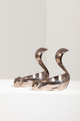 une paire de sculptures métalliques représentant deux oiseaux sur une surface blanche