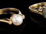 deux bagues en or ornées d'oplite et de perles sur un fond noir