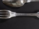two spoons and a fork on a black table