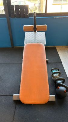 an orange bench in the middle of a gym room
