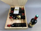 bottles of wine in a wooden box on a table next to a bottle of wine