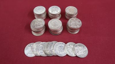 Plusieurs pièces d'argent de 25 centimes sont disposées sur un fond rouge
