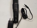 a close up of a hair clipper on a table with a charger