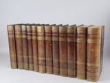 six vieux livres alignés sur une surface blanche