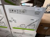 des cartons contenant des tondeuses à gazon empilés les uns sur les autres dans un entrepôt